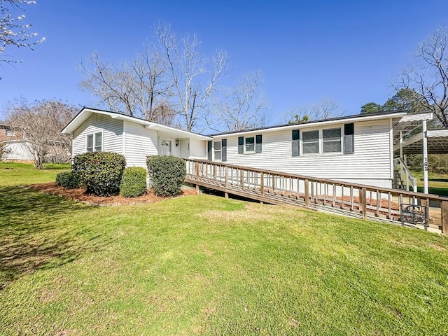 rear view of property featuring a lawn and a deck