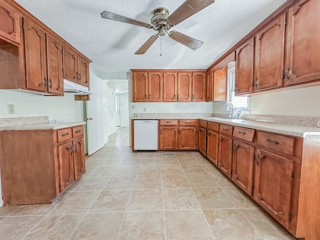 kitchen featuring brown cabinetry, light countertops, dishwasher, and a sink