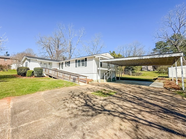 view of front of home featuring driveway, a wooden deck, a front lawn, and a detached carport