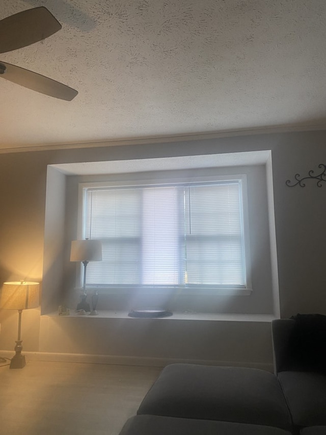 living room featuring a textured ceiling, ceiling fan, and crown molding