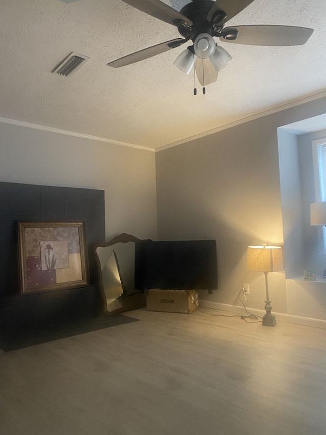 living room with a textured ceiling, ceiling fan, crown molding, and hardwood / wood-style flooring