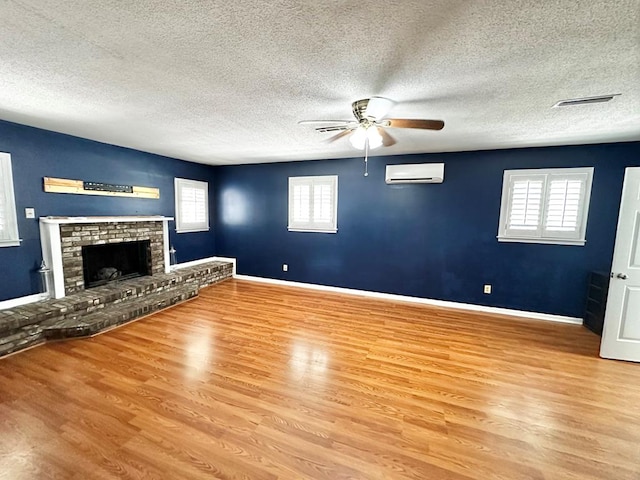 1006 Northfield Cir, Dothan, AL 36301 - unfurnished living room with a wall unit AC, ceiling fan, wood finished floors, a textured ceiling, and baseboards