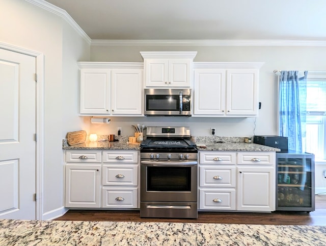 kitchen with ornamental molding, stainless steel appliances, white cabinets, dark hardwood / wood-style floors, and wine cooler