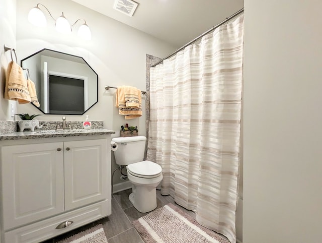 bathroom featuring curtained shower, vanity, and toilet