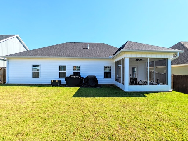 rear view of house featuring a sunroom and a yard