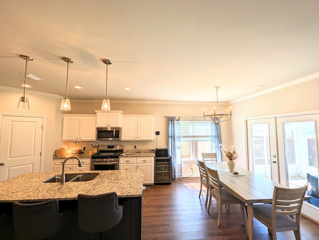 kitchen with appliances with stainless steel finishes, light stone counters, sink, dark hardwood / wood-style floors, and white cabinetry