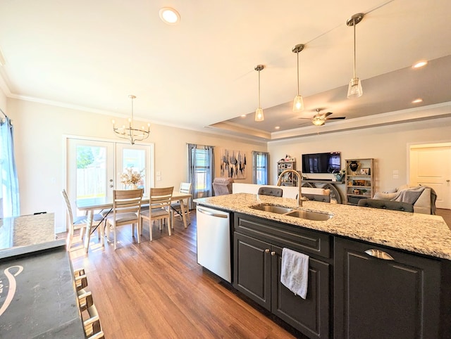 kitchen featuring light stone countertops, stainless steel dishwasher, ceiling fan with notable chandelier, sink, and pendant lighting