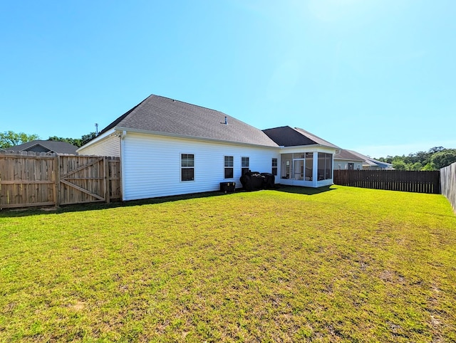 back of house featuring a sunroom and a yard