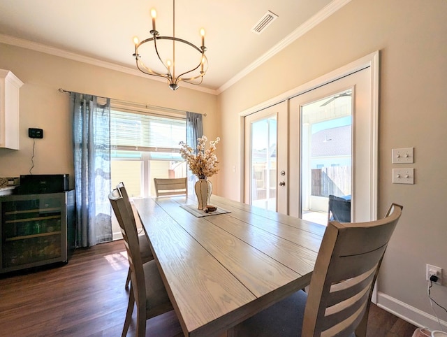 dining room featuring dark hardwood / wood-style flooring, an inviting chandelier, french doors, and ornamental molding