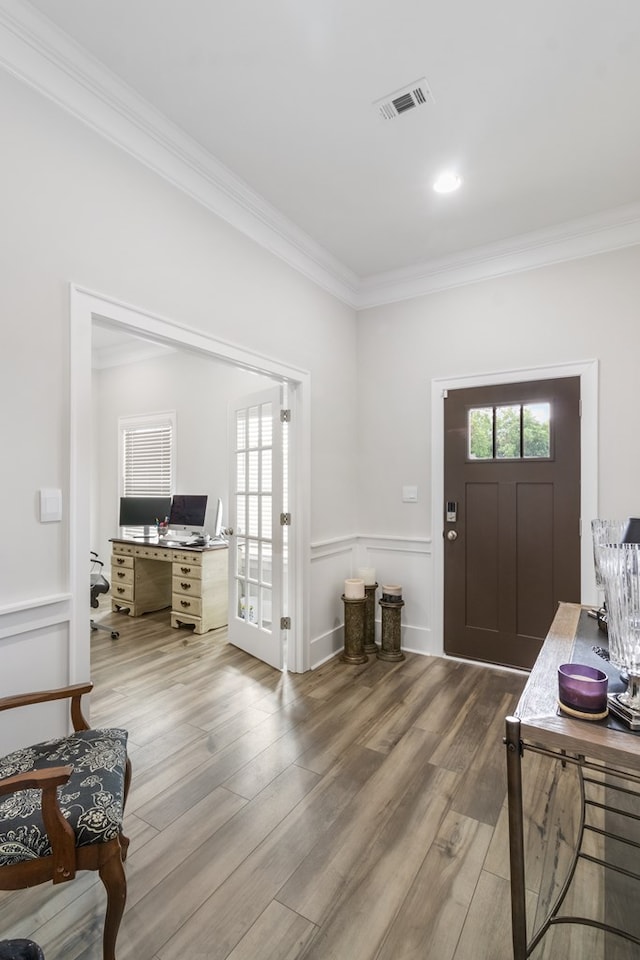 foyer entrance featuring hardwood / wood-style floors and ornamental molding