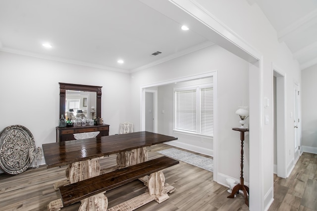 dining area with crown molding and light hardwood / wood-style floors