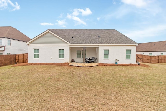 rear view of property featuring a lawn and a patio