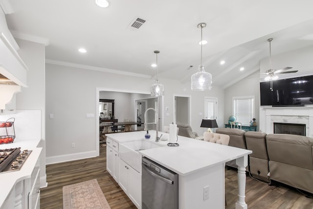 kitchen featuring sink, appliances with stainless steel finishes, white cabinetry, hanging light fixtures, and a center island with sink