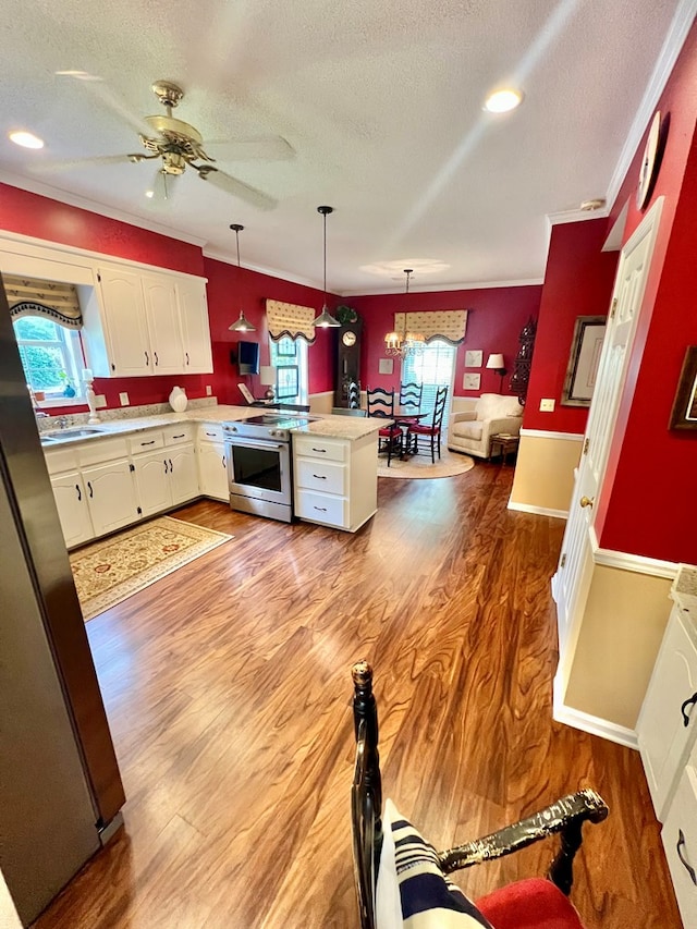 508 N Englewood Ave, Dothan, AL 36303 - kitchen featuring stainless steel stove, a textured ceiling, light countertops, a peninsula, and light wood-style flooring