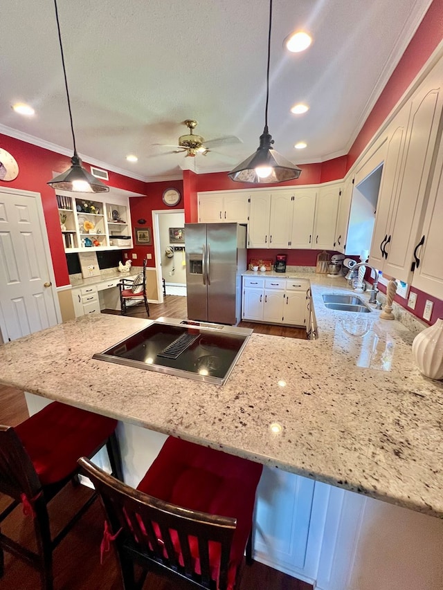 508 N Englewood Ave, Dothan, AL 36303 - kitchen with stainless steel fridge, stovetop with downdraft, white cabinetry, ornamental molding, and a kitchen breakfast bar
