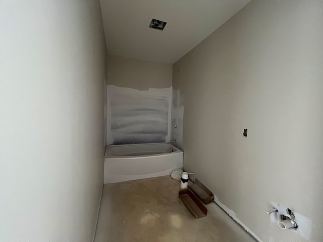 bathroom featuring concrete flooring and a tub to relax in