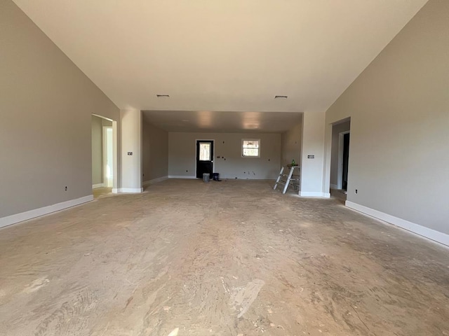 unfurnished living room featuring vaulted ceiling