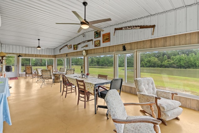 sunroom / solarium with a wealth of natural light, outdoor dining space, a ceiling fan, and a water view