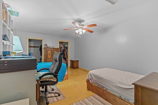 bedroom featuring visible vents, ceiling fan, a closet, baseboards, and a walk in closet