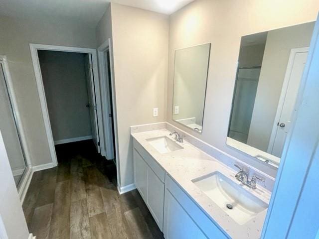 bathroom featuring a shower with door, vanity, and wood-type flooring