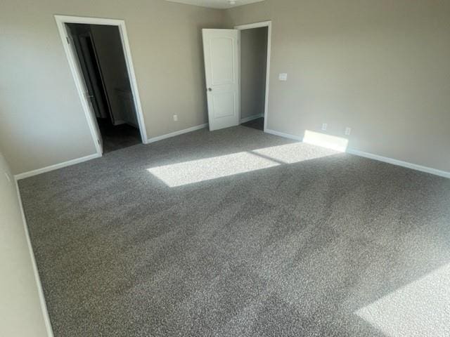 unfurnished bedroom featuring a walk in closet and carpet floors