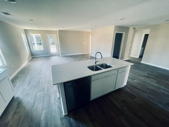 kitchen featuring dishwasher, sink, dark hardwood / wood-style floors, a center island with sink, and white cabinets