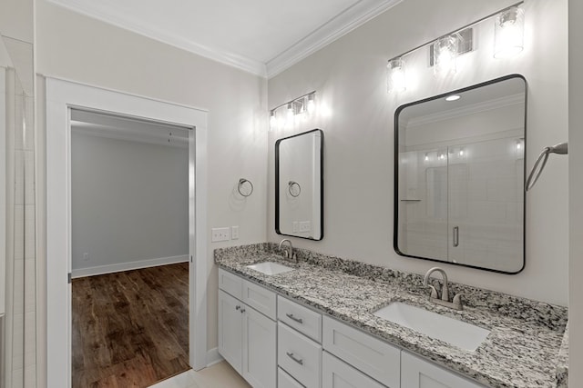 bathroom featuring ornamental molding, a shower with shower door, hardwood / wood-style floors, and vanity