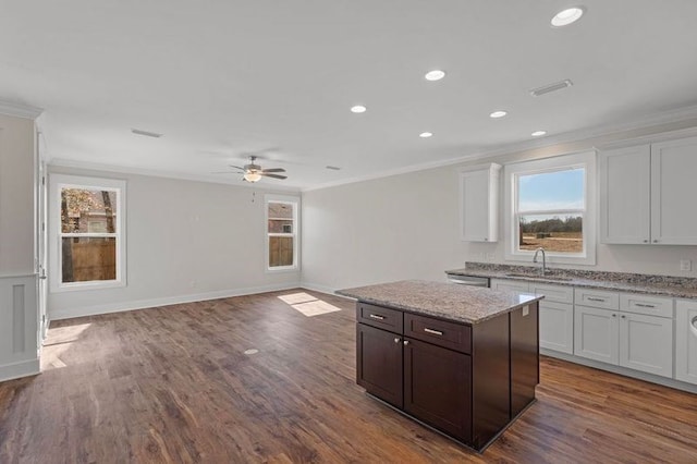 kitchen featuring dark brown cabinetry, sink, crown molding, and white cabinets