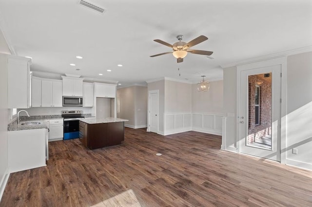 kitchen featuring sink, stainless steel appliances, ornamental molding, white cabinets, and a kitchen island