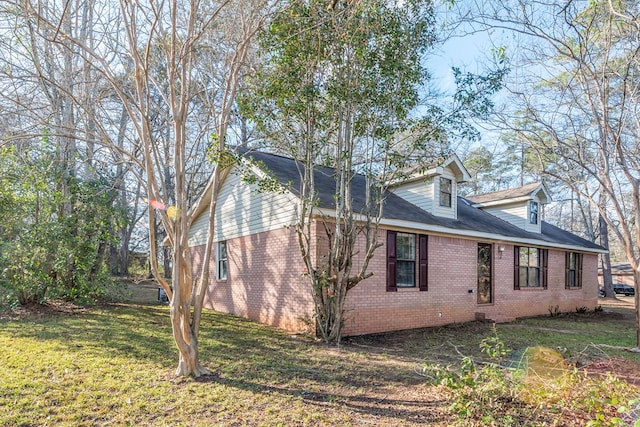 view of home's exterior featuring a lawn and brick siding