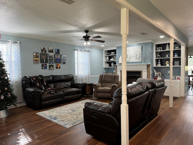 living room with a textured ceiling, dark wood-type flooring, ceiling fan, and a healthy amount of sunlight