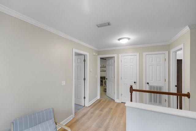 hallway with ornamental molding and light hardwood / wood-style flooring