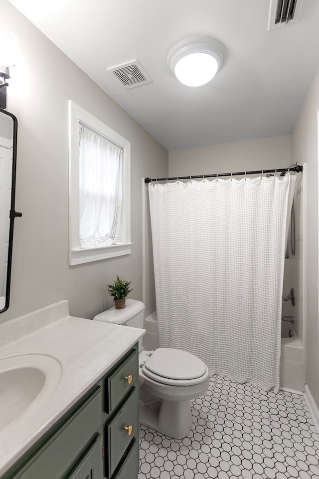 full bathroom featuring toilet, vanity, tile patterned floors, and shower / bath combination with curtain