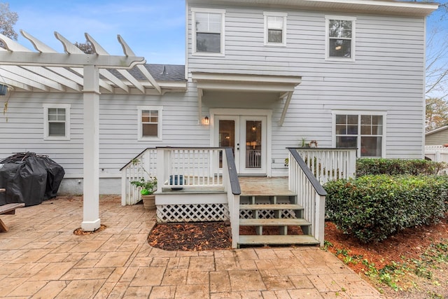 rear view of property featuring french doors, a deck, and a patio area