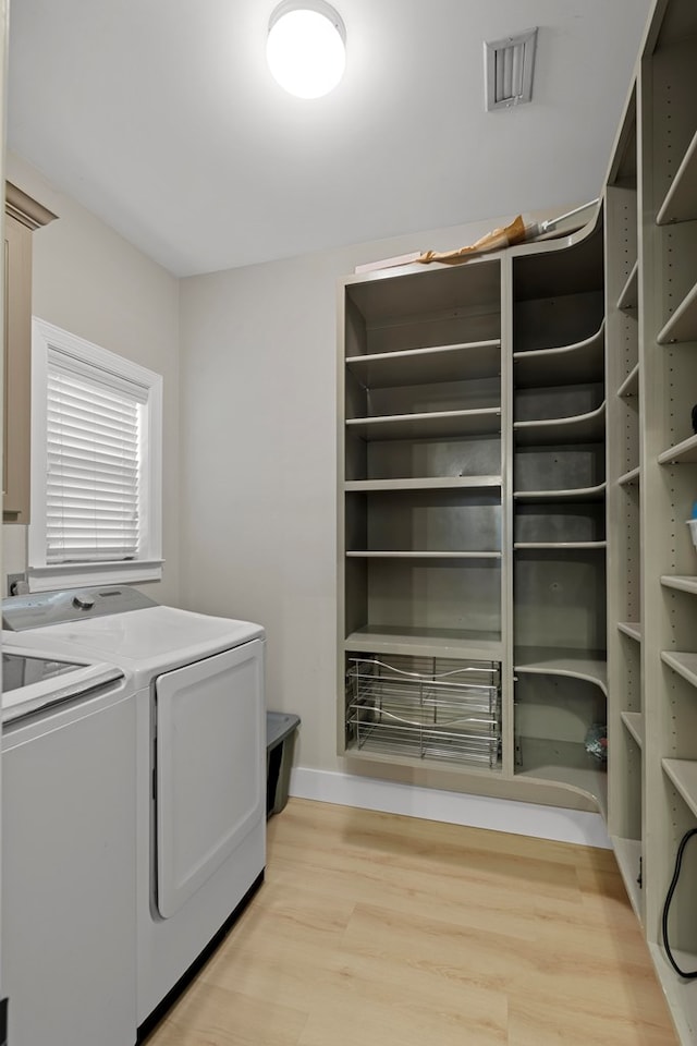 laundry room featuring independent washer and dryer and light wood-type flooring