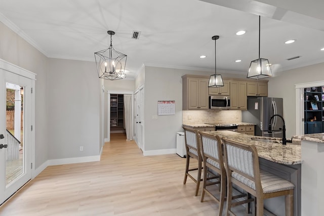 kitchen with light stone counters, light hardwood / wood-style flooring, a chandelier, decorative light fixtures, and stainless steel appliances