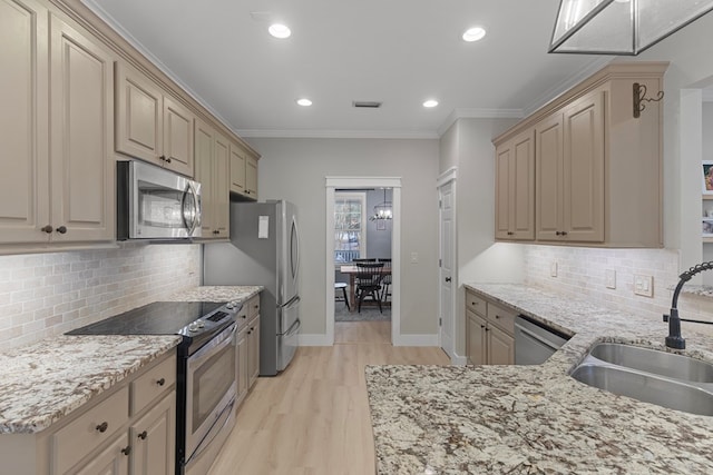 kitchen with ornamental molding, stainless steel appliances, tasteful backsplash, and sink