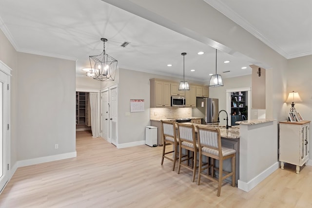 kitchen with light stone counters, stainless steel appliances, a chandelier, and hanging light fixtures