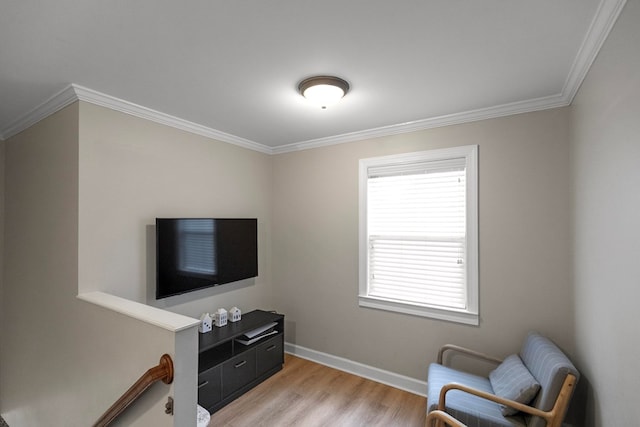 living area with crown molding and light hardwood / wood-style flooring