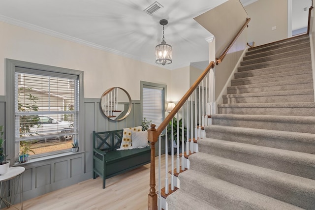 entryway featuring ornamental molding, hardwood / wood-style floors, and a chandelier