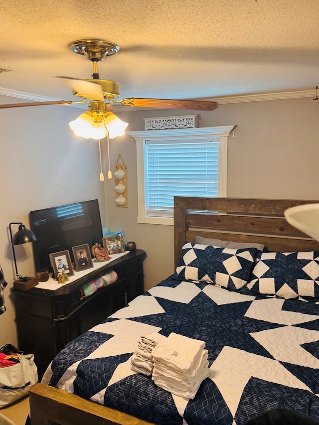 bedroom featuring ornamental molding, a textured ceiling, and a ceiling fan