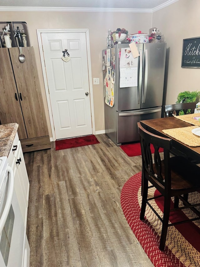 dining space featuring baseboards, ornamental molding, and wood finished floors