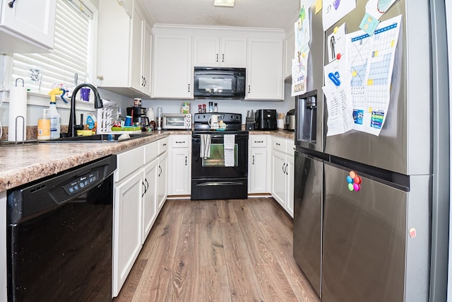 52 Oakwood Dr, Midland City, AL 36350 - kitchen featuring black appliances, wood finished floors, white cabinetry, light countertops, and a textured ceiling