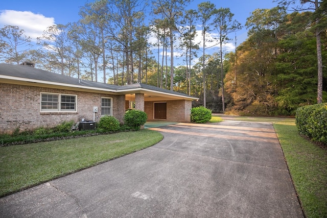 3408 Huntington Pl, Dothan, AL 36303 - view of front facade featuring concrete driveway, brick siding, a front yard, and a carport