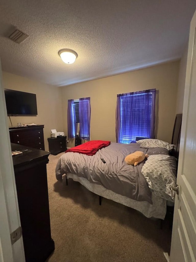 carpeted bedroom featuring a textured ceiling