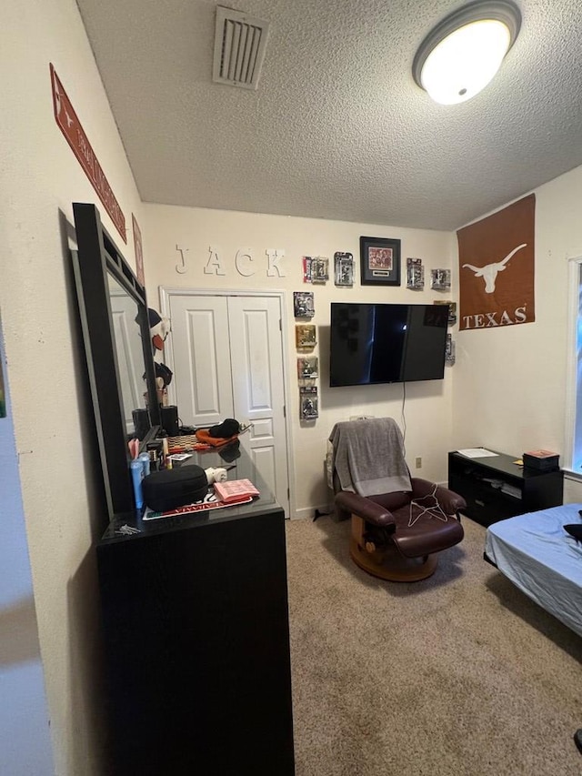 bedroom with carpet and a textured ceiling