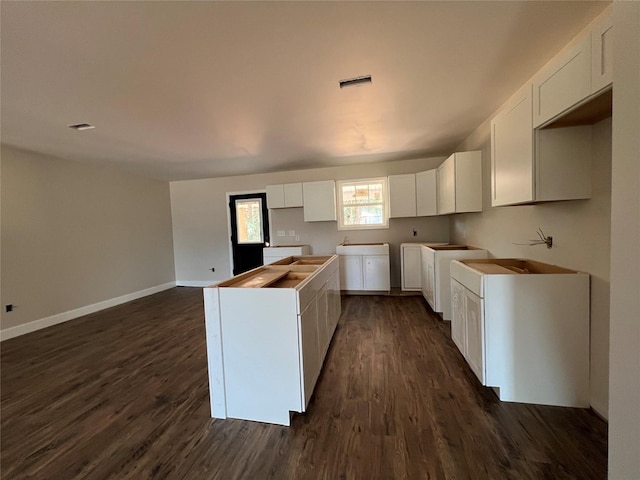 729 Sandstone Dr, Dothan, AL 36303 - kitchen featuring dark wood finished floors, white cabinetry, baseboards, a kitchen island, and washer / dryer