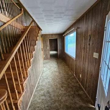 8159 State Highway 10, Shorterville, AL 36373 - hallway featuring wooden walls, carpet flooring, and stairs