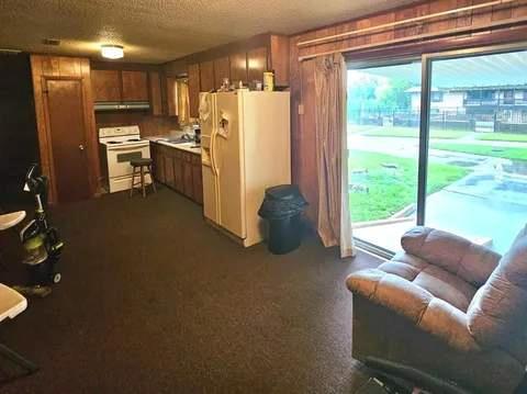 8159 State Highway 10, Shorterville, AL 36373 - kitchen with white appliances, brown cabinetry, light countertops, under cabinet range hood, and a textured ceiling
