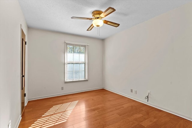 spare room featuring ceiling fan, light hardwood / wood-style floors, and a textured ceiling